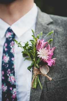 a man wearing a suit and tie with flowers in his lapel flower bouquet on his lapel