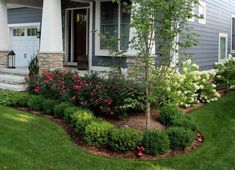 a house with flowers and trees in the front yard