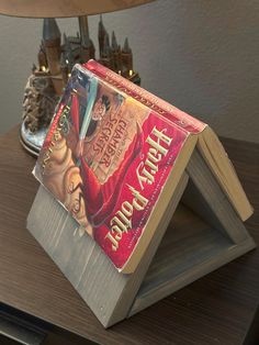 a book sitting on top of a wooden table next to a lamp and other items