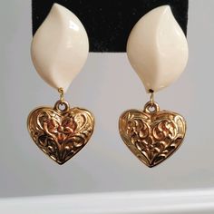 Off-White Teardrop With Goldtone Sculpted Heart. Post Backing. Elegant Teardrop Earrings With Heart Charm, Vintage Brown Teardrop Earrings, Ornate Teardrop Brass Earrings, Vintage Gold Heart-shaped Earrings, Retro Gold Heart-shaped Earrings, Vintage Heart, Teardrop Earrings, Gold Tones, Off White