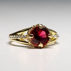 Gorgeous gold plated Garnet Crystal Ring-  gemstone- with dazzling crystals. size 7 1/4. It shines like real gold. GREAT Gift! No Tarnish It will come in a gift bag Gold Cubic Zirconia Crystal Birthstone Ring, Gold Crystal Birthstone Ring With Cubic Zirconia, Formal Gold Ruby Ring With Round Stone, Gold Promise Ring With Stone Setting, Classic Gold Crystal Ring With Birthstone, Gold Crystal Ring With Accent Stones For Promise, Gold Crystal Promise Ring With Accent Stones, Dazzling Gold Crystal Ring For Anniversary, Gold Jeweled Rings For Gift