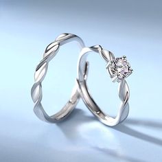 two wedding rings with diamonds on top of each other, one is white gold and the other is silver