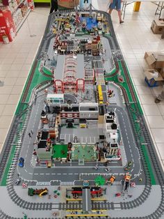 a large model train set on display in a store with people looking at the tracks