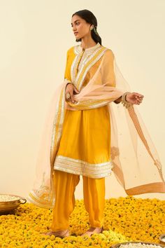 Glaze mustard kurta with gota patti work and highlighted with basra moti. Paired with salwar and rose pink dupatta.
Component: 3
Pattern: Embroidered
Type Of Work: Gota and Bead Work
Neckline: Mandarin
Sleeve Type: Long Sleeves
Fabric: Kurta - Silk Chanderi; Salwar - Bamberg Satin; Dupatta - Silk Organza
Color: Yellow
Other Details: 
Gota and bead work
Embroidered dupatta
Occasion: Wedding,Mehendi - Aza Fashions Gota Patti Embroidery, Yellow Kurta, Indian Fashion Designers, Pernia Pop Up Shop, Silk Organza, Kurta Set, Mandarin Collar, Set For Women, Festival Wear