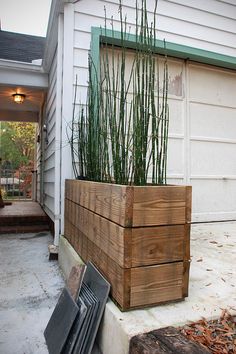 a wooden planter sitting on the side of a house