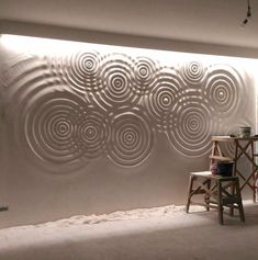 a room with a chair and a wall made out of metal circles on it's side