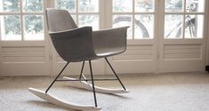 a white rocking chair sitting in front of a window