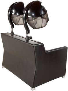 two black helmets are on top of a brown leather chair with silver legs and arms