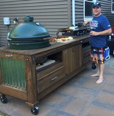 a man standing next to an outdoor grill