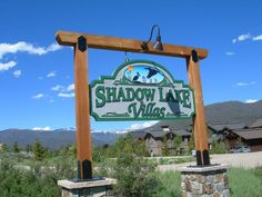 a sign for shadow lake village in the mountains