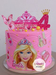 a pink birthday cake decorated with barbie dolls and accessories