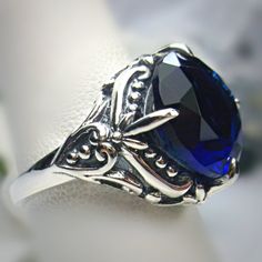 Simulated Blue Sapphire Ring  Orb Design#82 Custom Made This is a brand new Victorian inspired solid sterling silver filigree ring. This stunning ring is set with a 6ct Simulated/Man-made Blue Sapphire gemstone. The round cut blue sapphire is 13mm (1/2th of an inch) in diameter. The inside of the band is marked 925 for sterling silver. Notice the beautiful intricate floral prong design and swirls of the silver filigree setting and band. This is a lovely new, well made, and charming ring; and it Gold Jewlry, New Victorian, Blue Sapphire Gemstone, Filigree Jewelry, Victorian Design, Sterling Silver Filigree, Filigree Ring, Blue Sapphire Rings, Silver Filigree