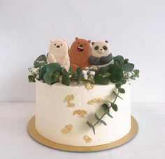 there is a cake decorated with three bears on the top and plants in the bottom