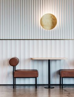 two chairs and a table in front of a wall