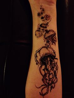 a person with a tattoo on their arm that has an octopus and jellyfish in it