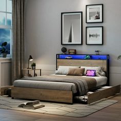 a bedroom with a bed, nightstands and pictures on the wall above it in front of a window