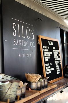 there is a sign that says silos baking co on the wall next to some cups