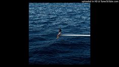 a person sitting on the edge of a boat in the ocean