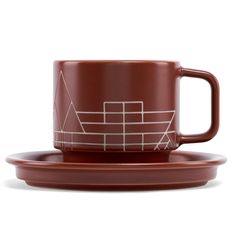 a brown coffee cup and saucer sitting on top of a white plate with an abstract design