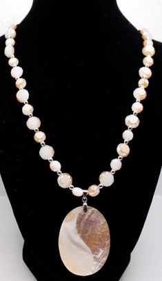 A gorgeous statement pendant which boasts an oval shape with shell material consisting of different shapes that are cracked beige and white mosaic pieces.  The pendant is matched with 2-tone color faceted opaque flat crystal beads (2 sizes--8mm and 10mm) with tiny silver rondelles to provide added dimension to this stunning necklace. The entire ensemble is completed with a silver chain with a lobster clasp.  The back of the pendant is Mother-of-Pearl. Earrings are part of the price and you can request different ear wires at no extra charge.  Earrings are currently on fishhooks and you may request studs or leverbacks. Mosaic Pieces, Statement Pendant, Shell Pendant, Stunning Necklace, Shell Necklaces, Necklace Set, Crystal Beads, Silver Chain, Necklace Lengths