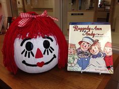 a raggedy pumpkin with a book beside it