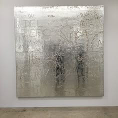 an abstract painting with writing on it in a white walled area next to a wall