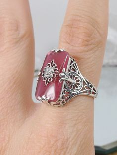 Petal Pink Glass Ring Antique Jeweled Jewelry, Art Deco Filigree Jewelry As Gift, Art Deco Filigree Jewelry For Gift, Art Deco Hallmarked Jewelry For Wedding, Heirloom Round Jeweled Jewelry, Art Deco Hallmarked Wedding Jewelry, Antique Cubic Zirconia Jewelry Gift, Vintage White Gold Filigree Jewelry, Sterling Silver Art Deco Jewelry For Wedding