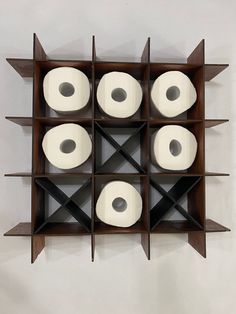 several rolls of toilet paper are arranged in a geometric pattern on a wall mounted shelf