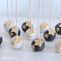 cake pops decorated with gold stars and white frosting are arranged on a table, ready to be eaten