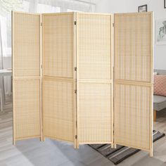 the room divider is made out of bamboo and has four panels on each side