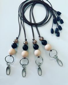 several different necklaces with black and white beads on a brown leather cord next to each other