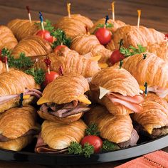 croissants with meat and cheese on them are arranged in a platter