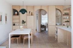 an open kitchen and dining room with white tile flooring