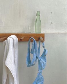 an old pair of bras hanging from a hook on a wall next to a bottle