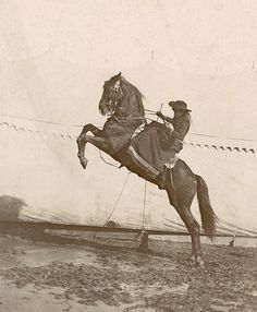 a man riding on the back of a horse in an old fashioned black and white photo