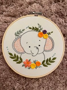 an elephant with flowers on it's head is shown in this embroidery hoop art project