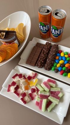 two plates with candy, candies and drinks on them