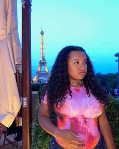 a woman standing in front of the eiffel tower