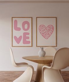 two framed pictures on the wall next to a table with chairs and a vase in front of it