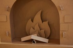 a cardboard fire place sitting on top of a table next to a paper cutout