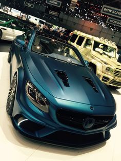 several different colored cars on display in a showroom