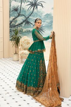 Beautiful traditional bottle green designer bridal dress for wedding occasion, beautifully decorated with gold embroidery, motifs and sequins. This traditional lehnga comes in latest design that make your look more trendy and perfect for any wedding event. Top: This designer bridal dress complemented by short frock style in traditional bottle green color is embellished with fully gold embroidery, crystals and motifs work. Neckline is highlighted with embroidery patch and with full length motif d Green Traditional Dresses, Designer Bridal Dress, Short Frocks, Copper Work, Short Frock, Frock Style, Clothing Studio, Embroidered Chiffon, Bridal Dress Design