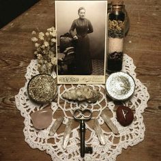 a table topped with lots of different items on top of a lace doily next to a card