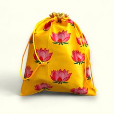 a small yellow bag with red flowers on the front and side, sitting on a white surface