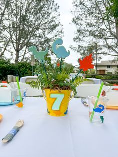 the table is set up for an outdoor birthday party with colorful decorations and place settings