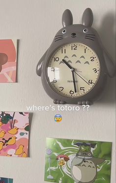 a clock that is on the side of a wall next to pictures and magnets