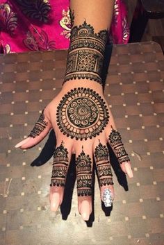 a woman's hand with henna tattoos on it