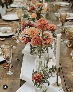 the table is set with flowers and candles