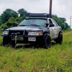 the police car is parked on the side of the road near power lines and telephone poles