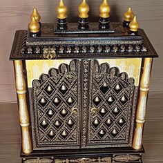 an ornate wooden cabinet with gold and black decorations